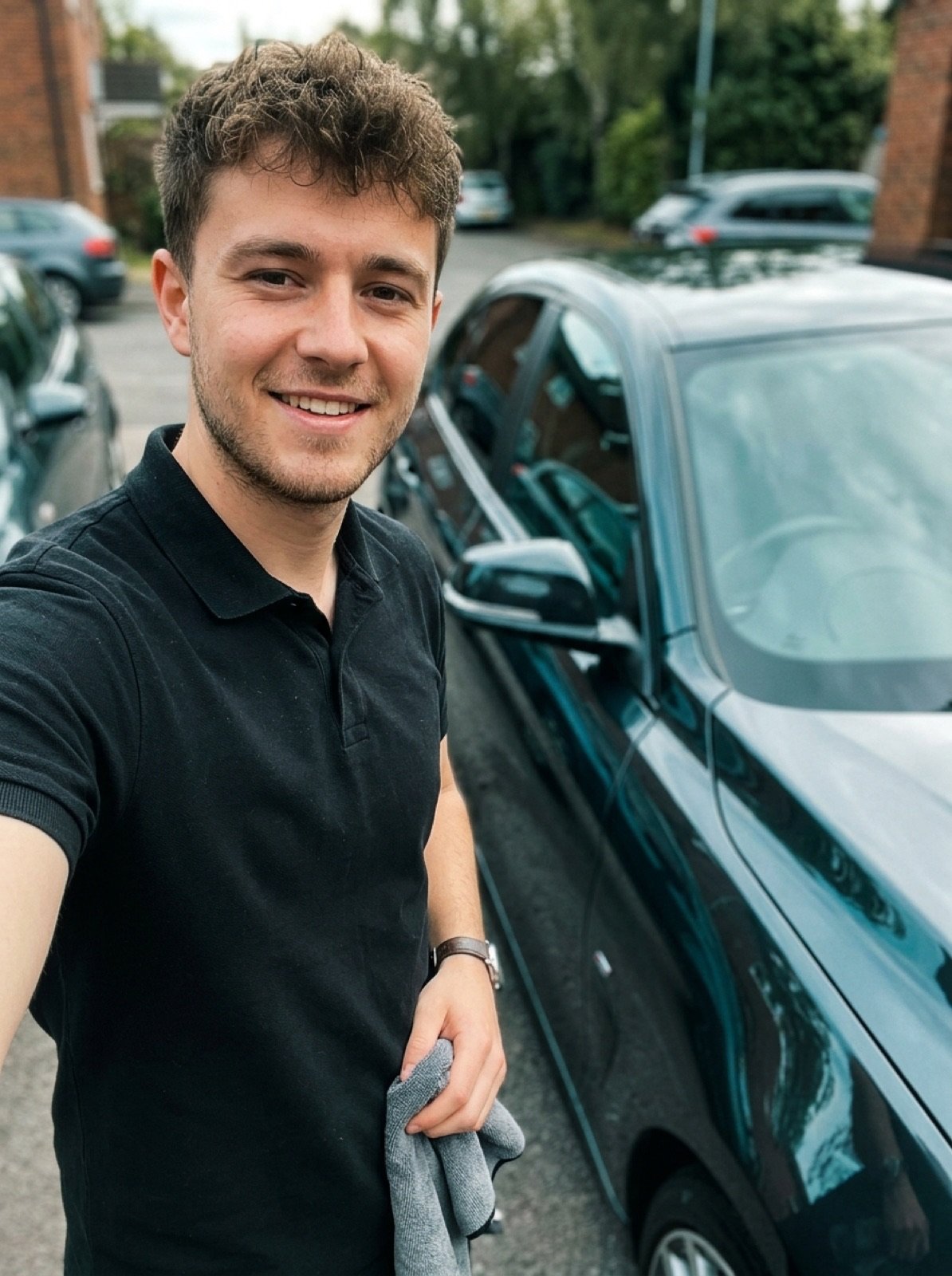 Daniel Wohlfahrt, Gründer von WohlFahrt Mobile Car Cleaning, mit Mikrofasertuch neben frisch poliertem Fahrzeug